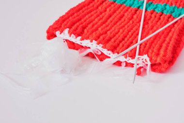 Geri dönüştürülmüş plastik konseptten iplik, örgü iğneleri, gri arka plan ve kırmızı başlık üzerindeki dilimlenmiş plastik paketler, temel çevre koruma kavramı, atık geri dönüşümü