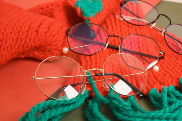 红色针织围巾上的几副时髦眼镜 圣诞节风格的概念 节庆眼镜销售 光学商店复制空间 — 图库照片