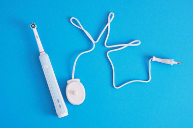 onlar için mavi arkaplan fotokopi alanı üzerinde elektrik mavi diş fırçası ve şarj istasyonu