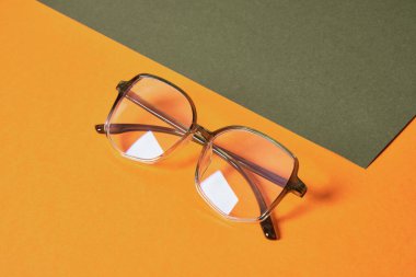 Yeşil ve turuncu geometrik arkaplan üzerindeki moda gözlükleri üst görünüm renklerinin fotokopisi