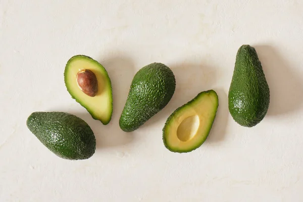 Frische Ganze Und Scheiben Geschnittene Avodkado Früchte Auf Hellem Hintergrund — Stockfoto