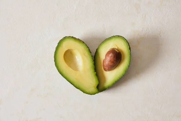 Two Halves Avocado Lie Heart Shape Fresh Whole Sliced Avocado — Foto Stock