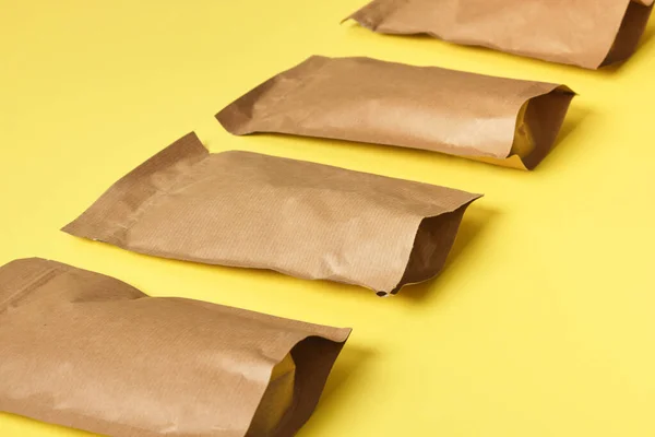 paper bags on yellow background pattern Eco friendly packaging, paper recycling, zero waste, natural products concept. Copy space.