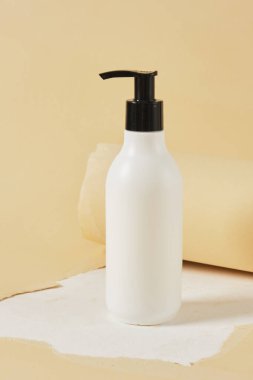 moe up blank bottle with dispenser for cosmetics on creative background from torn paper and textured surface, cosmetics for body skin care presentation, mockup without labels