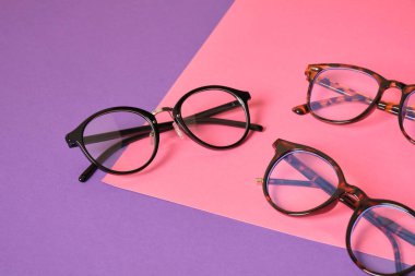 Pembe ve mor geometrik arkaplanda farklı moda gözlükleri, modaya uygun gözlük çerçeveleri boşluğu kopyalıyor