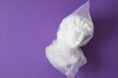 David 'in kafası şeffaf bir plastik torba içinde mor bir arka plan fotokopi alanı üzerinde, sanat çöküşü, küçümseme ve umutsuzluk