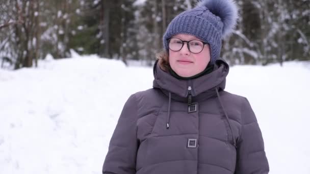 Jonge vrouw in bril en winter kleding buiten — Stockvideo