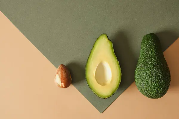 Frische Ganze Und Scheiben Geschnittene Avodcado Früchte Auf Grünem Hintergrund — Stockfoto