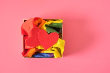 İki kırmızı keçeli kalp, bir kutuda Igbt topluluğunun gökkuşağı sembolü, pembe arka plan, sevgililer günü konsepti, eşcinsel çiftler için romantizm