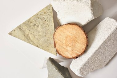 Taşlardan yapılmış ürün sunumu için bir sahne ve ahşap çember, beton bloklar ve testere kesimi, boş bir şablon, reklam için bir vitrin.