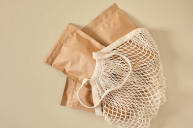 Alışveriş için plastik poşetler, bej arka plan görüntüsü, ürünler için taklit paketler, teslimat için paketler, çevre dostu doğal malzemeler, CO2 nötr