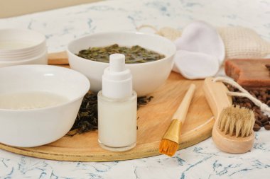 pirinç suyu şişesi, vücut bakımı, doğal kozmetik konsepti fermente edilmiş güzellik bakımı, ahşap tepside doğal malzemelerden yapılmış çay maskesi ve sabun.