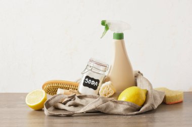 Masada ağ torbası, sprey şişesi, soda, limon ve doğal temizlik süngeri, toksik olmayan temizleyici.