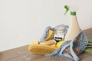 Eko temizlik seti masada, sprey şişesi, soda, limon ve doğal temizlik süngeri, toksik olmayan temizleyiciler.