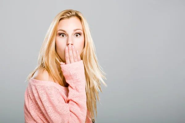 Überrascht hübsches blondes Mädchen mit einer Hand im Mund — Stockfoto