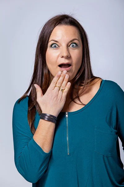 Verrast volwassen vrouw die betrekking hebben op haar mond met de hand — Stockfoto