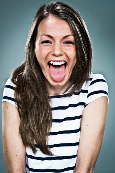 Junge glückliche Frau streckt ihre Zunge heraus — Stockfoto