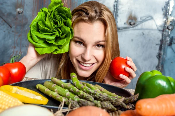 Ung kvinna leker med grönsaker — Stockfoto