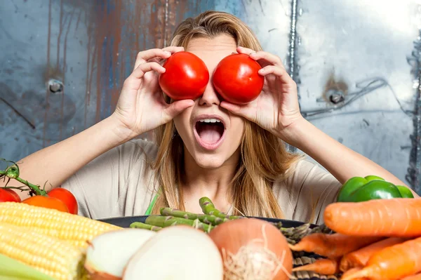 Ung kvinna leker med ett par tomater — Stockfoto