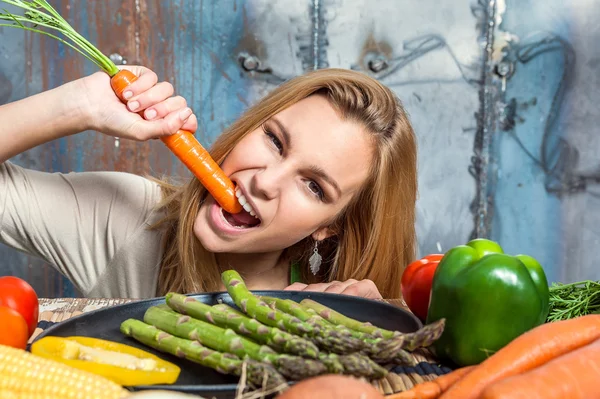 Ung kvinna biter en morot — Stockfoto