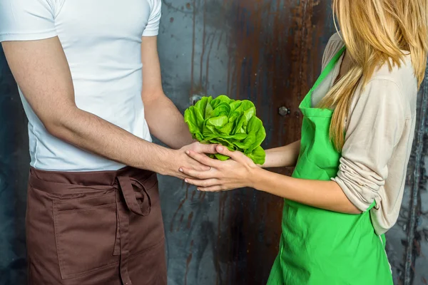 Young Couple Holding a Lettuce in the Kitchen — Stock Photo, Image