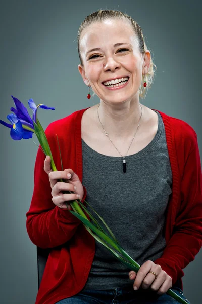 Glad ung leende med en violett blomma — Stockfoto