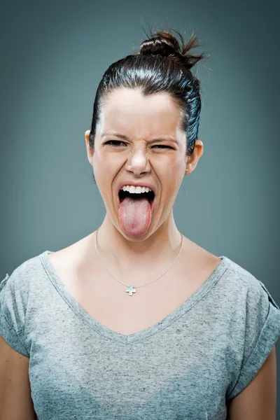 Gelukkig jongedame haar tong uitsteekt — Stockfoto