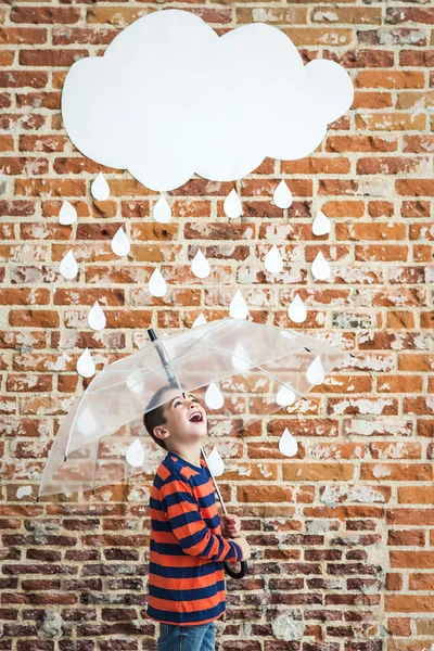 Criança pequena sob Raindrops de papelão branco — Fotografia de Stock
