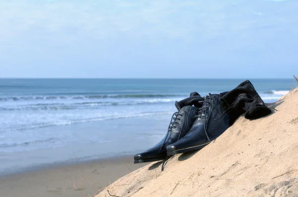 Black shoes in the sand — Stock Photo, Image