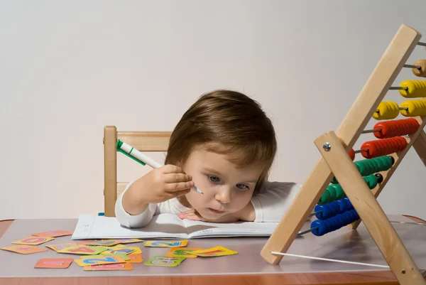 Little girl plays with toy abacus and learns to count — Stock Photo, Image