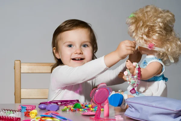 Menina brinca com uma boneca — Fotografia de Stock