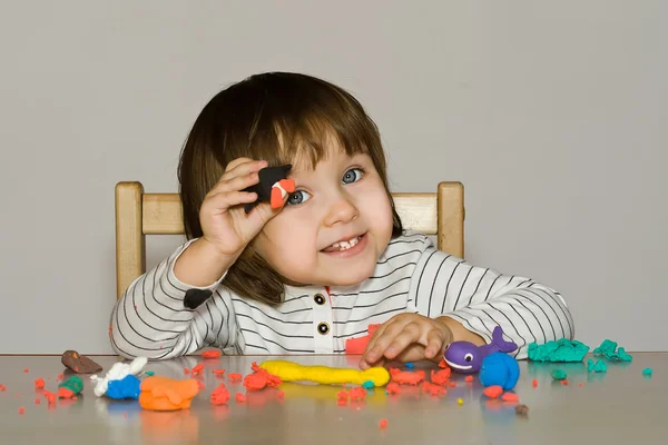 Portret meisje rommelt met kleurrijke deeg geïsoleerd op grijze achtergrond — Stockfoto