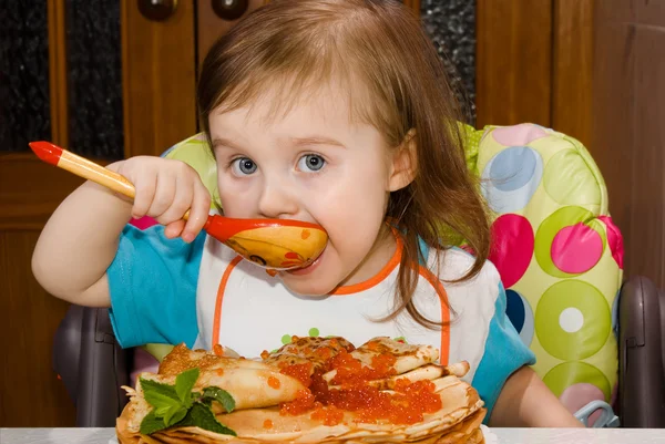 Little girl eating red caviar — Stock Photo, Image