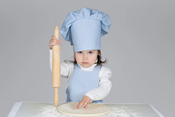 Beautiful little girl masrer chief cooking pizza — Stock Photo, Image