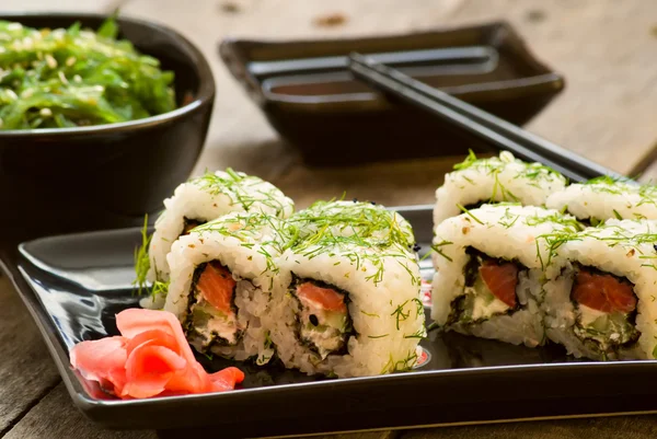 Sushi und Chuka-Algensalat mit Sojasauce auf Holztisch — Stockfoto
