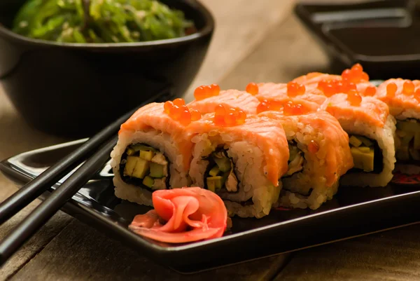 Ensalada de sushi y chuka con salsa de soja sobre mesa de madera — Foto de Stock