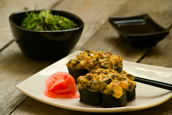 寿司和竹卡用酱油木桌上的海藻沙拉 — 图库照片