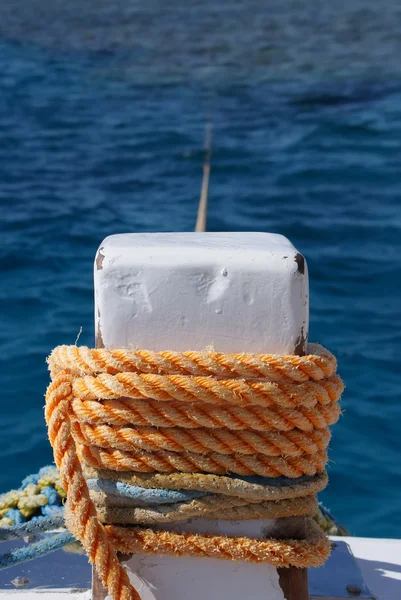 Close-up of mooring bollard with orange rope — Stock Photo, Image