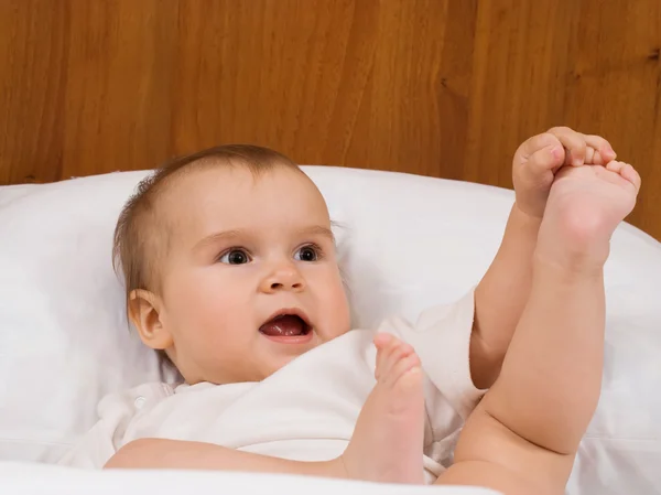 Kleines und süßes Baby spielt im Bett — Stockfoto