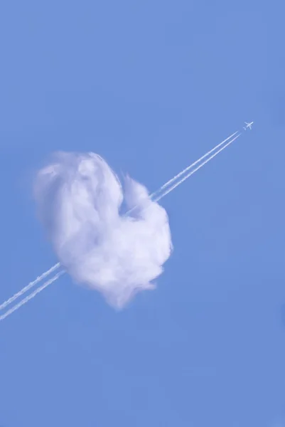 Flugzeug fliegt durch herzförmige Wolke — Stockfoto