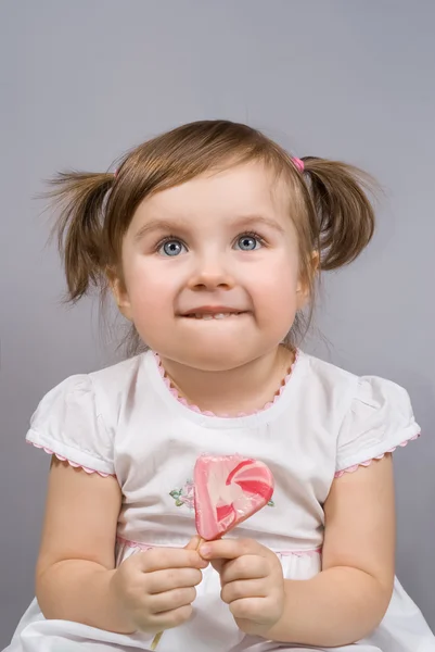 Retrato de una niña feliz sosteniendo una piruleta grande — Foto de Stock