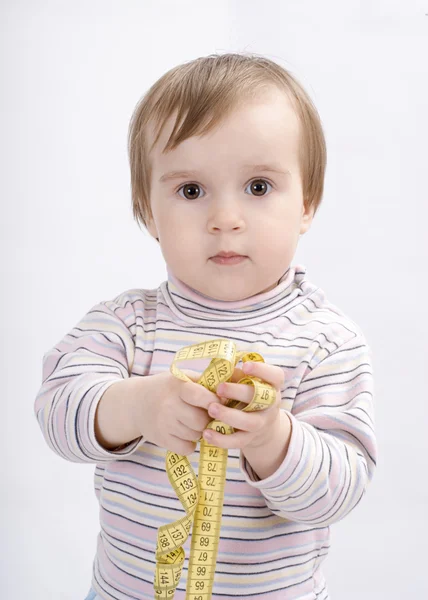 Adorable niña con una cinta métrica en las manos —  Fotos de Stock