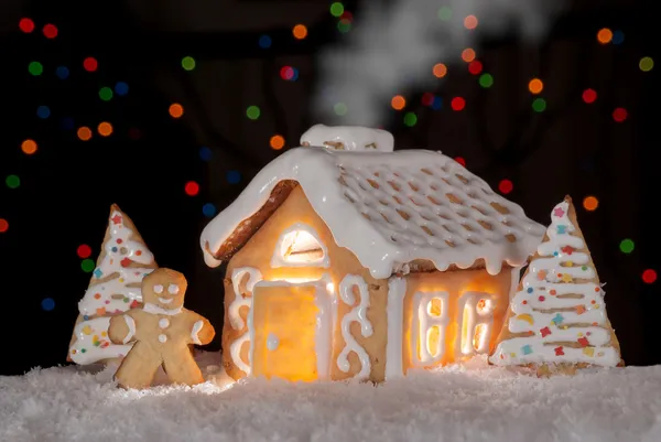 Gingerbread house with gingerbread man and christmas trees — Stock Photo, Image