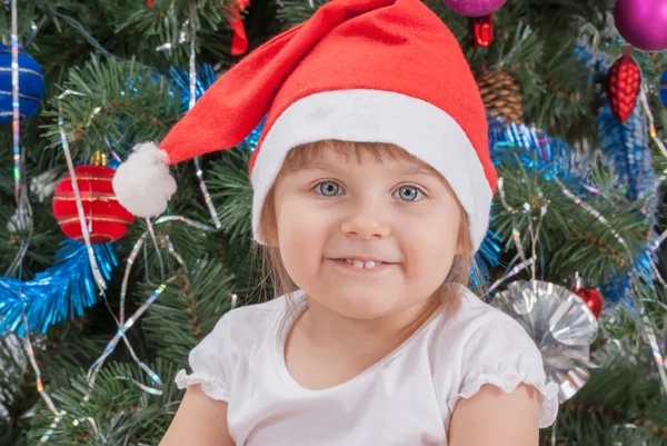 Porträtt av glad söt liten flicka i röd santa hatt — Stockfoto