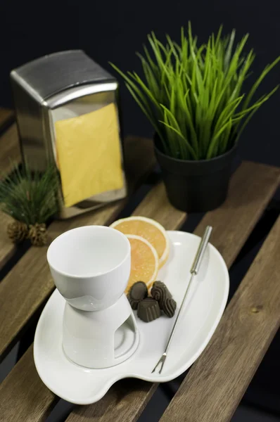 Conjunto de fondue de China y rebanada naranja en mesa de madera — Foto de Stock