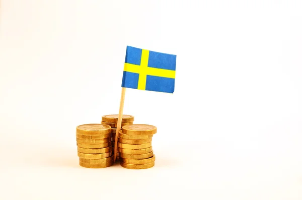 Swedish flag and coin piles Royalty Free Stock Photos