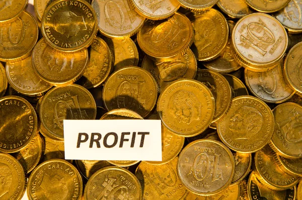 Segno di profitto in una pila di monete d'oro — Foto Stock