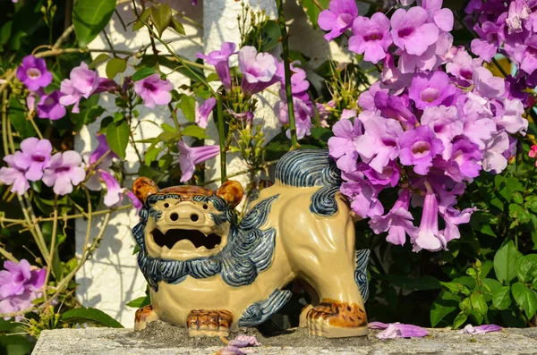 Figura di Shisa e fiori rosa — Foto Stock