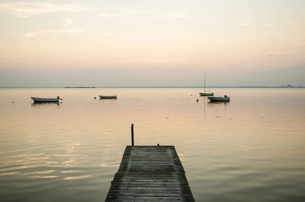 Old jetty with anchored rowing boats in the water — Stock Photo, Image