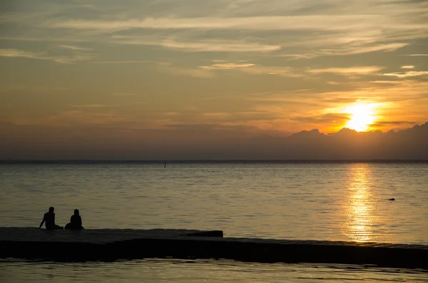 Pareja viendo atardecer en un muelle —  Fotos de Stock